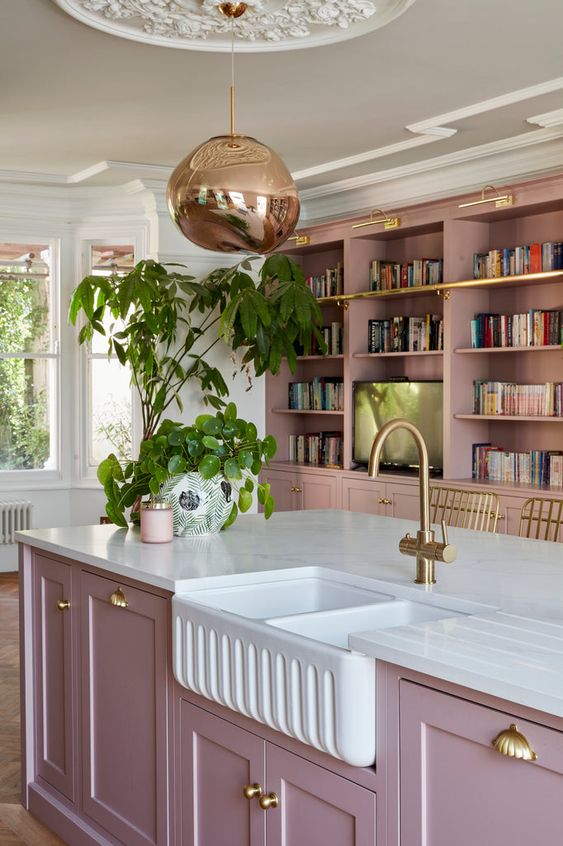a mauve kitchen with shaker cabinets, with bookcases, a large kitchen island, brass and gold touches is pure chic