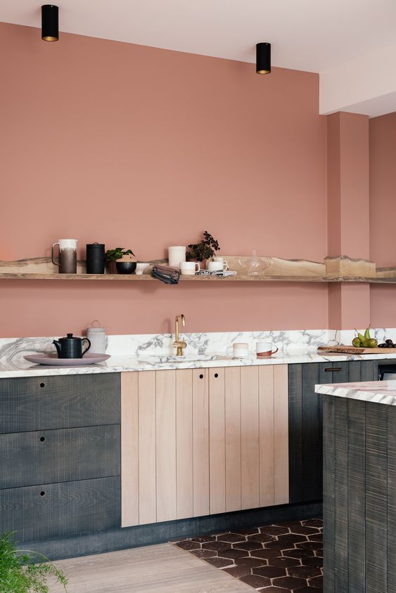 a salmon pink kitchen with dark-stained cabinets, a white countertops, a living edge ledge used for decor and storage