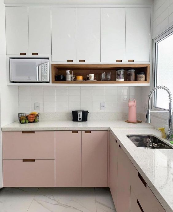 a two-tone kitchen with upper white and lower pink cabinets, a white tile backsplash and white stone countertops is clean and chic