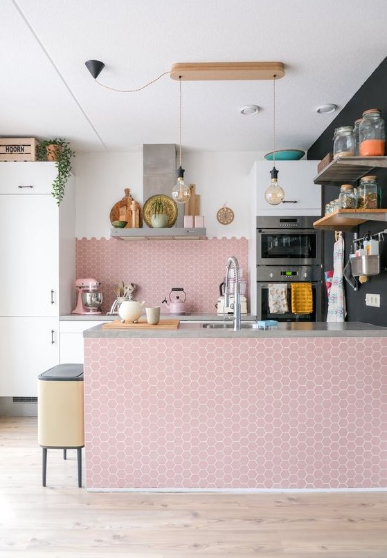 an airy kitchen with white cabinets and a large pink hex tile backsplash and kitchen island is really amazing