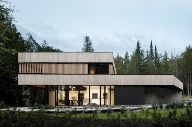 This minimalist home with bold architecture and natural materials used was built for a couple on a lake