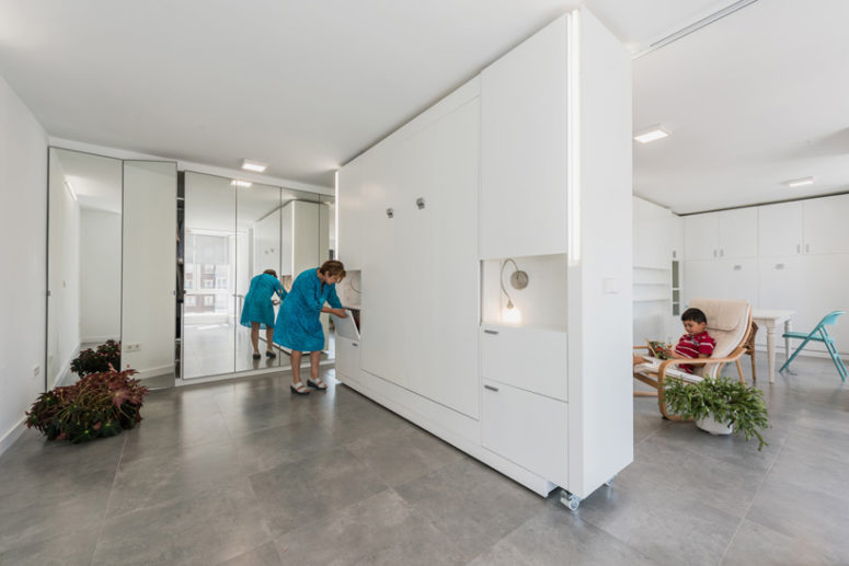 creative apartment's storage solution This wall is placed on casters and is packed with storage modules to save even more space