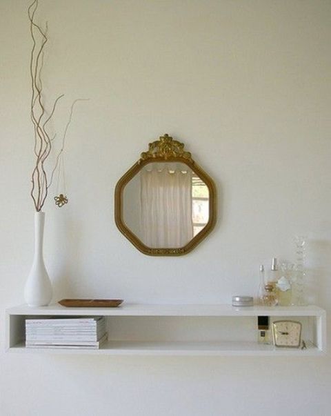 a clean, simple and elegant floating console with an open storage space and a refined mirror over it