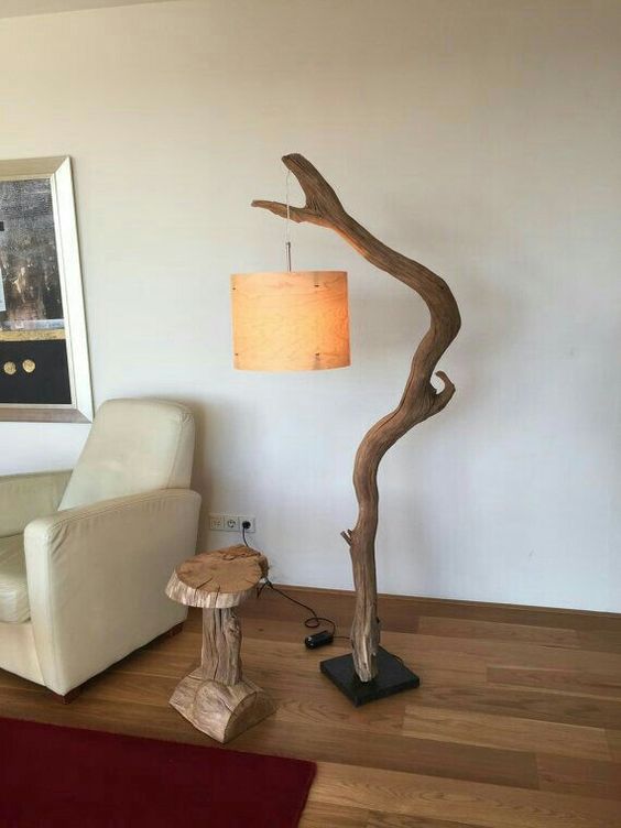 a large and bold floor lamp of a tree branch, a stylish stone base and a fabric lampshade for a natural touch