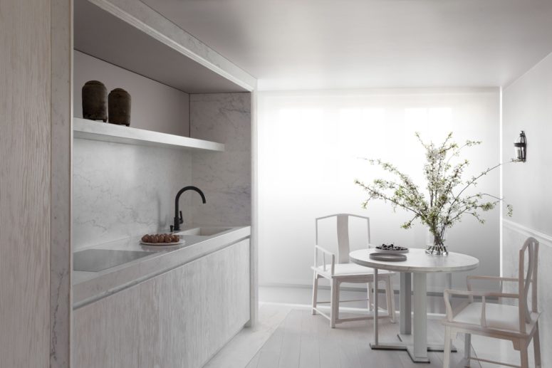 functional minimalist eat in kitchen design The eat-in kitchen is done with white wooden cabinets and marble and there's a matching dining set