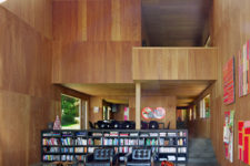 07 The space divider is a giant bookshelf and the upper floor features more private spaces