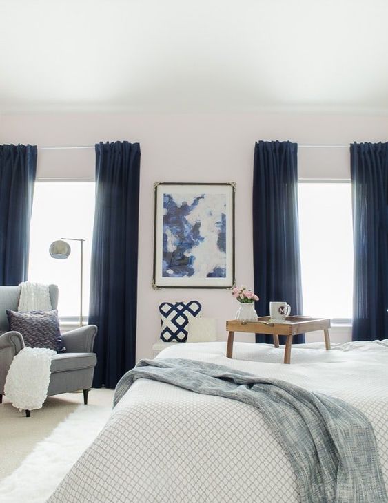 thick navy curtains add a touch of drama to the room and tone down the natural light making the bedroom cozier