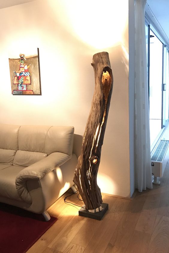 a large floor lamp made of a weathered and old hollow oak trunk for a natural feel