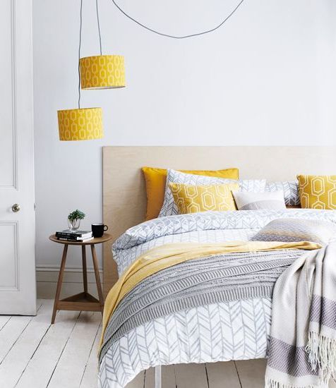 yellow printed lampshades echo with pillows and a blanket and add color to the neutral space