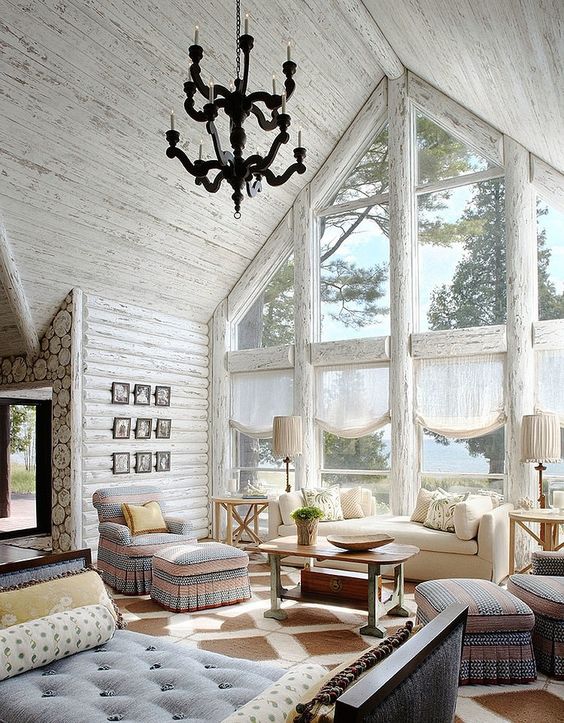 a rustic space with an attic roof is highlighted with whitewashed wood walls and ceiling plus frames of the windows