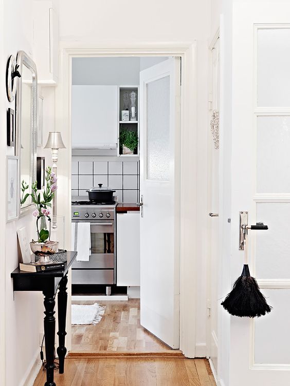 a small black console table can be placed even in a very small walkway like this one