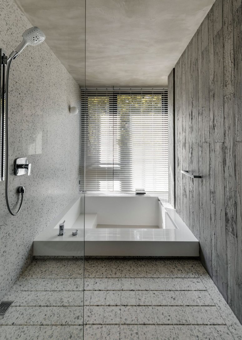 The master bathroom is done with stone and there's a large sunken bathtub