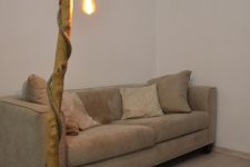 09 a large floor lamp with a tree trunk and a pendant lamp that wraps around the trunk
