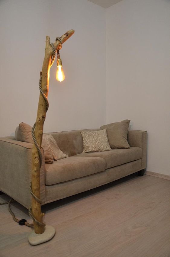 a large floor lamp with a tree trunk and a pendant lamp that wraps around the trunk
