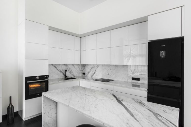 The kitchen is done in black and white with marble surfaces