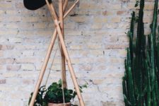 12 a wooden coat rack made of wood sticks and with a suspended planter in a basket to enliven your space
