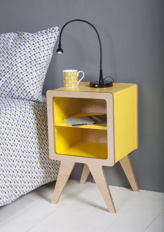 a modern nightstand of yellow lacquer and plywood with open storage for a bold touch