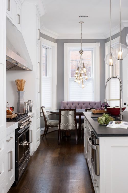 an awkward nook is used as an eating space accented with pendant lights and cool upholstered furniture