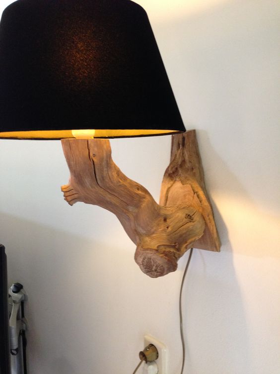 a chic wall Lamp of a weathered old oak branch with a black velvet lampshade for a statement