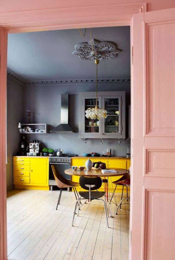 a graphite grey kitchen color blocked with sunny yellow lower cabinets and a gorgeous pendant lamp