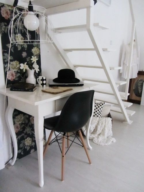 a feminine workspace with a large chandelier and an airy staircase that lets light in and looks lightweight