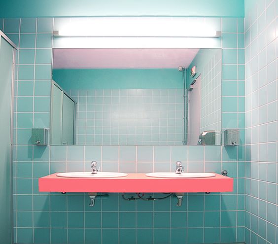 a simple idea of color blocking in a powder room with bright blue tiles and a bold pink floating vanity