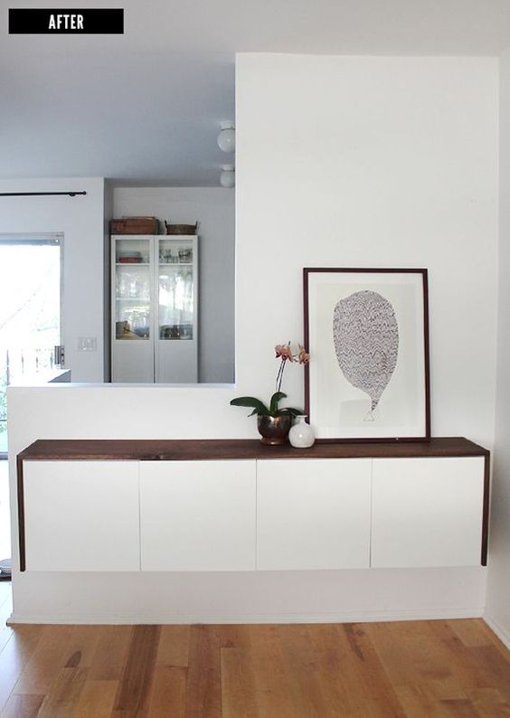 a stylish floating console of a white dresser with a dark-stained tabletop is all you need for a contemporary entryway