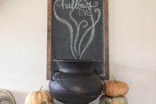 21 a tiny console table with real pumpkins, a cauldron and a chalkboard sign over the console