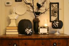 23 a vintage-inspired display with black and white pumpkins, buntings and blackbirds on branches