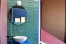 23 green tiles and a bright blue vanity with an eye-cathcy shape make the powder room extra bold