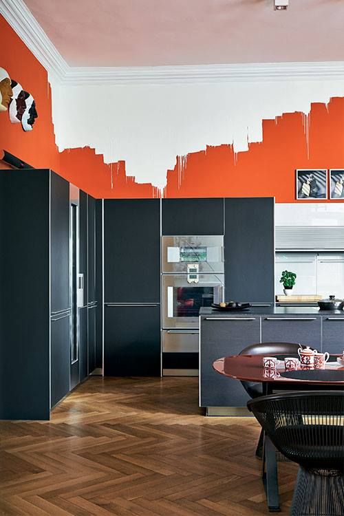 orange walls with a graphic effect create also a color block one with graphite grey cabinets