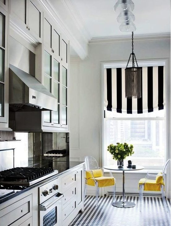 a chic kitchen with farmhouse cabinetry, a striped curtain that echoes with the floors, a round table and acrylic chairs with yellow upholstery