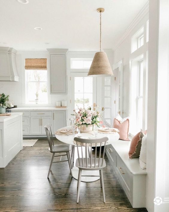 a serene modern farmhouse kitchen with shaker cabinets, a windowsill bench and a table plus chairs is lovely
