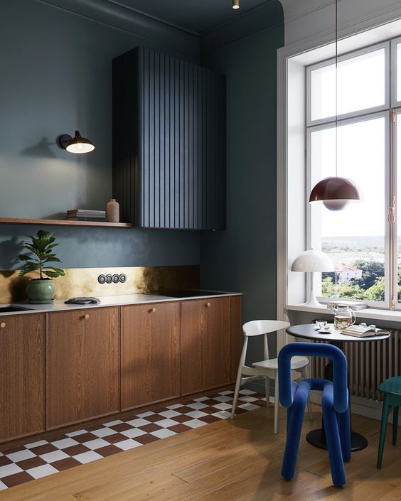 a stylish and eye-catchy moody kitchen with limewash walls and stained cabinets, a black fluted hood, a small table and mismatching chairs