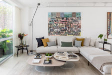 02 The living room is done with neutrals and colorful touches, it’s filled with light through a glazed wall