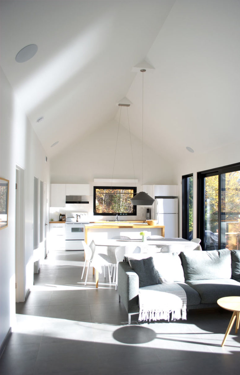 The main space of the cabin is an open layout that includes a kitchen, a dining space and a living room and is filled with light
