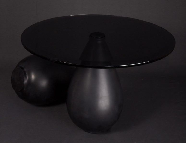 unique all black table The shape of the table is unique, it's a marble base shaped as a tear and a round glass top