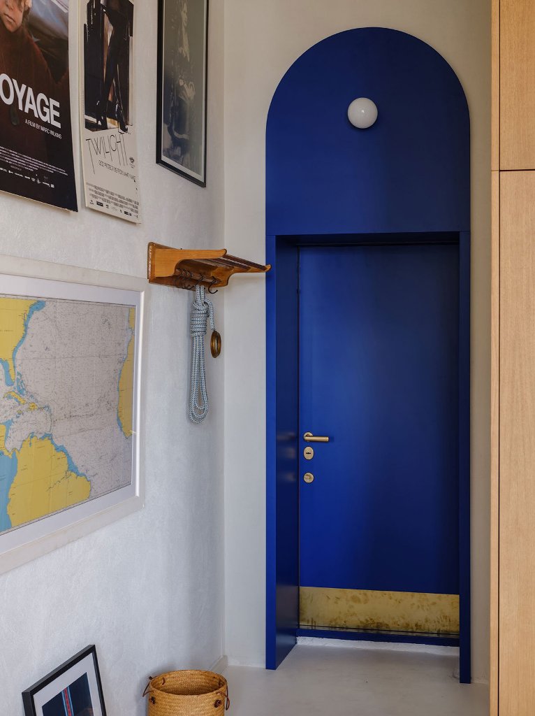 This is an entrance door done in bold blue with gold leaf and the whole wall is covered with posters