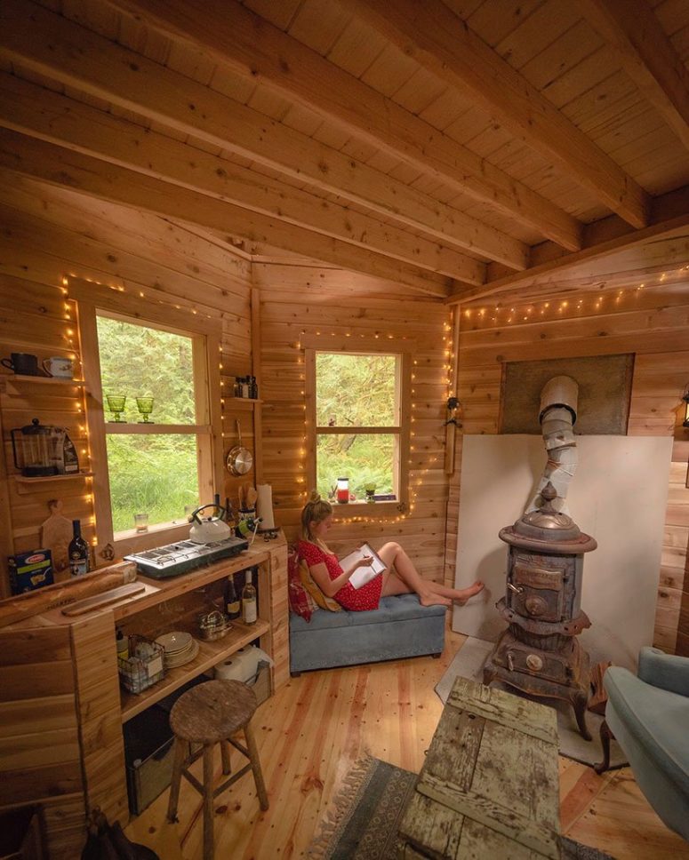 tiny kitchen with open storage Inside you'll see a tiny kitchen cabinet with open storage, shelves, a little stove and a large vintage hearth that works