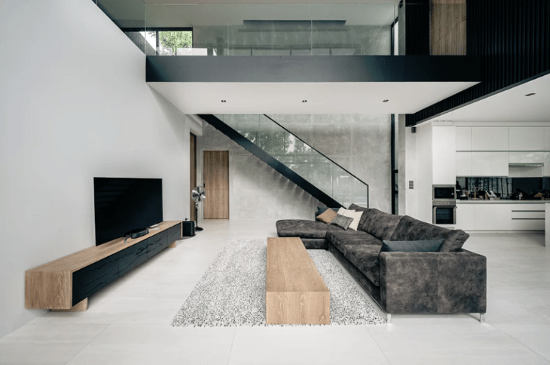 The living room is done with contemporary wooden furniture and a large L-shaped sofa that welcomes