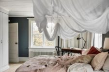 03 The master bedroom is a peaceful space with a large bed with a suspended canopy and a desk byt the window