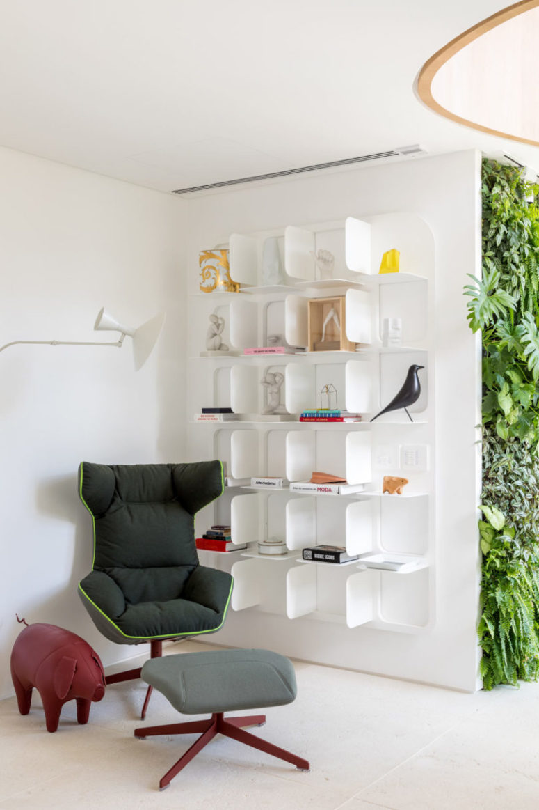 The reading nook is bold and catchy, there's an ultra modern chair with a footrest and unique bookshelves