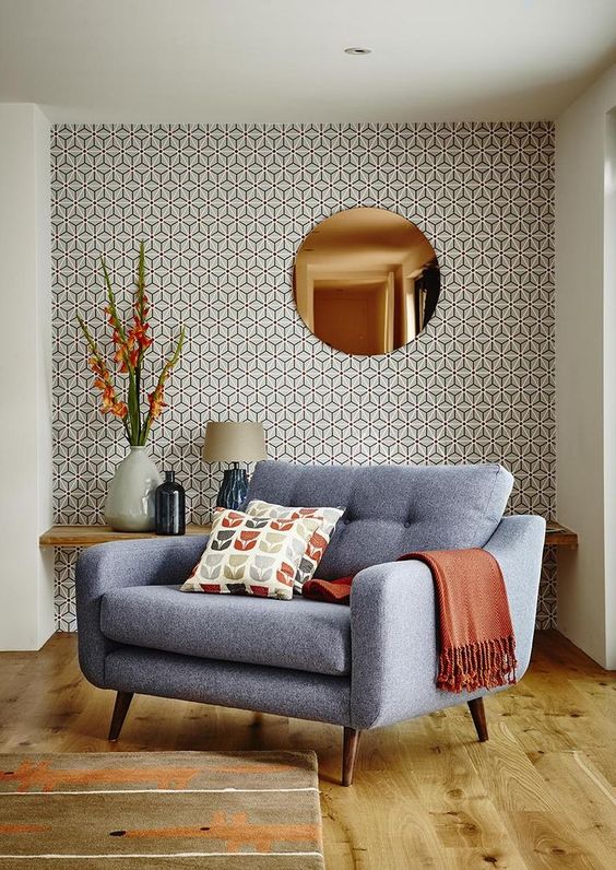 a chic mid-century modern nook with printed wallpaper and bright warm shades