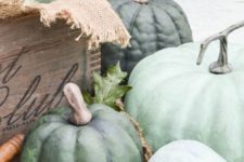 04 decorate your space with a crate filled with green heirloom pumpkins and some fresh foliage for simple rustic decor