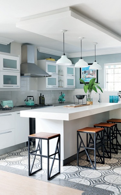 The kitchen is done in greys and white, with geometric prints and comfortable furniture