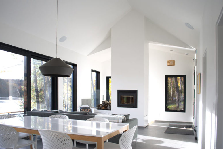 The living room is done with a built-in hearth, a grey sofa and the main thing here is large windows that bring in light