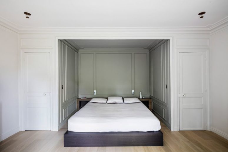 The master bedroom also shows off a niche with wall panelling, a platform bed and a storage headboard