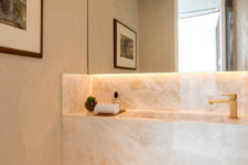 06 The powder room is done with stone and additional lights, the design is seamless
