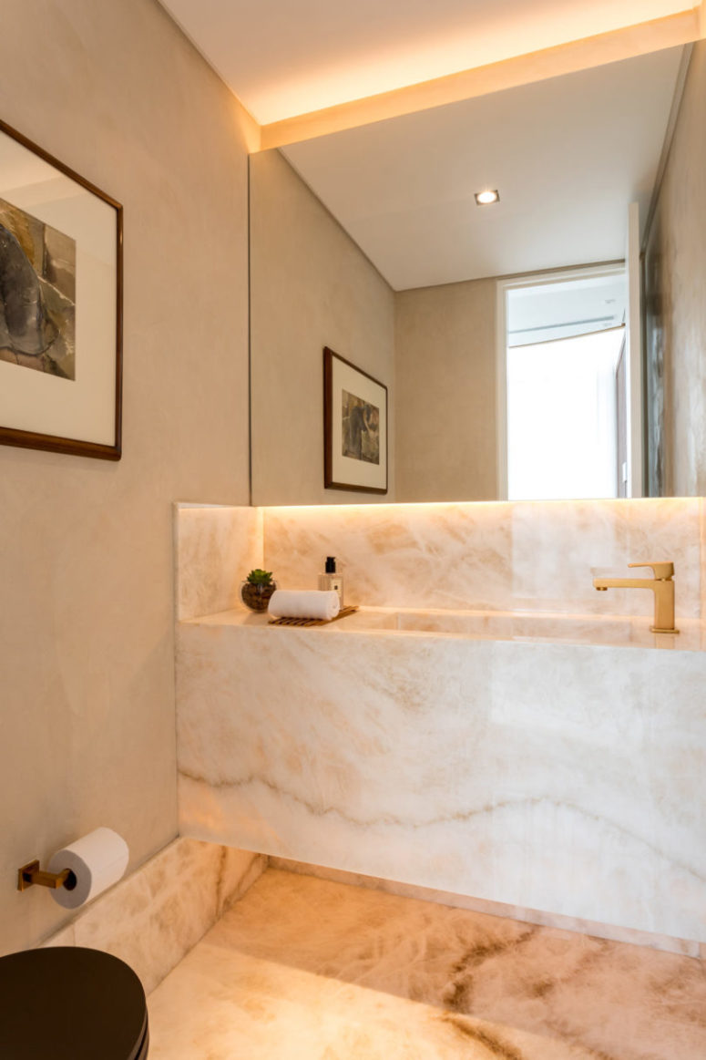 The powder room is done with stone and additional lights, the design is seamless