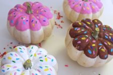 06 colorful pumpkins painted as glazed donuts with sprinkles for a fun and quirky touch